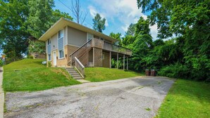A two-story house with a covered porch and a staircase leading to the second floor.