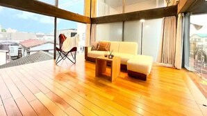 Una sala moderna con piso de madera, un sofá, una mesa de centro y una silla.