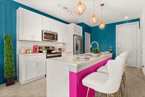 A modern kitchen with white cabinets, a central island, bar stools, and pendant lighting. - Chic 1-bedroom apartment in vibrant San Antonio with WiFi, fitness room (San Antonio)