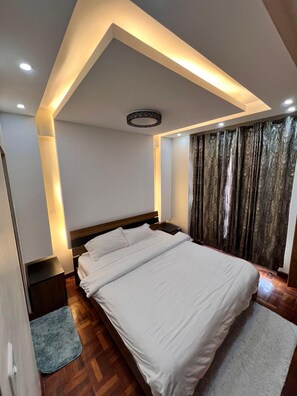 A modern bedroom with a large bed, recessed ceiling lighting, and a decorative ceiling feature. - Cosy Nairobi 1bdr Apartment for Two in Westlands (Nairobi)
