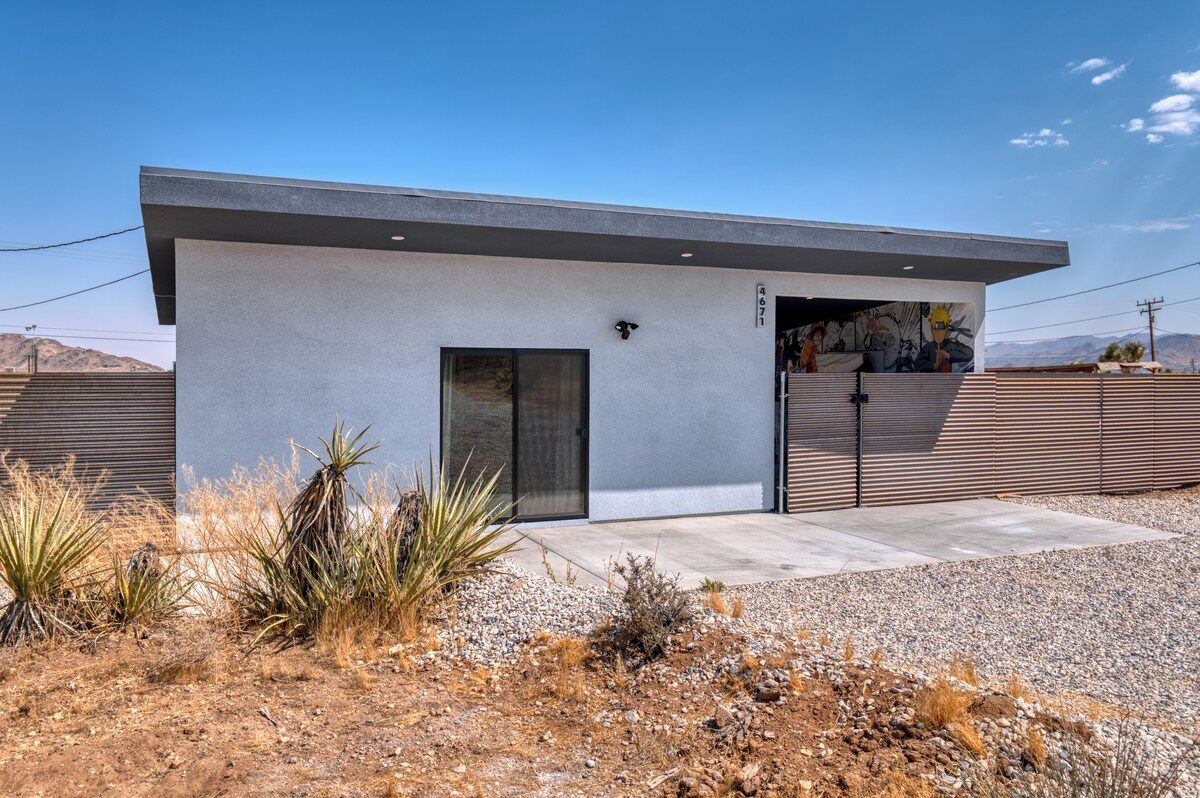 A modern building with a flat roof, a large door, and a small window.