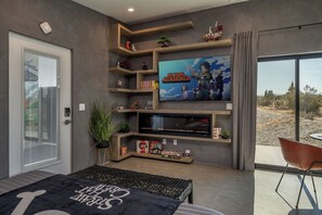 A modern living room with a large flat-screen TV, built-in shelves, and a comfortable seating area.