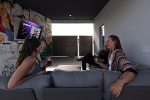 A modern living room with a large flat-screen TV displaying a streaming service interface, a couch, and a coffee table.