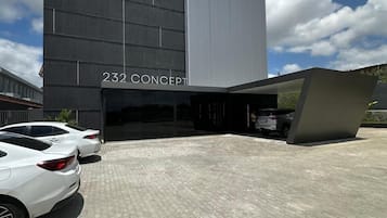 232 Concept building features a unique facade with a large, flat roof section and a paved area for parking.