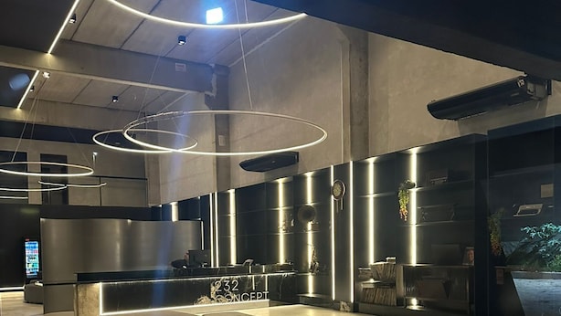 Un intérieur moderne comprenant un comptoir d’accueil, un espace détente et un éclairage de style industriel.