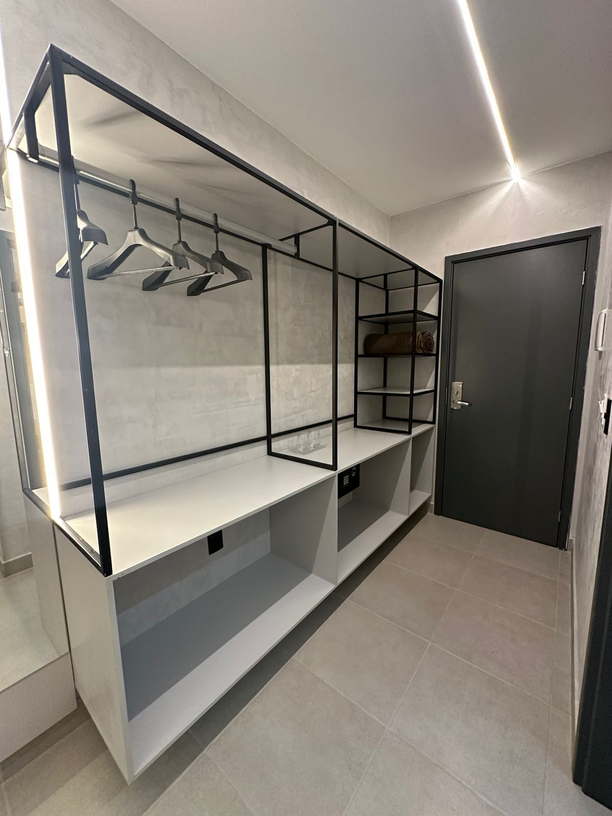 Una habitación moderna y minimalista con estanterías integradas y un armario.