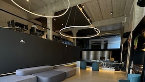 Un intérieur moderne avec un canapé d’angle, un coin bar et une cuisine en arrière-plan.