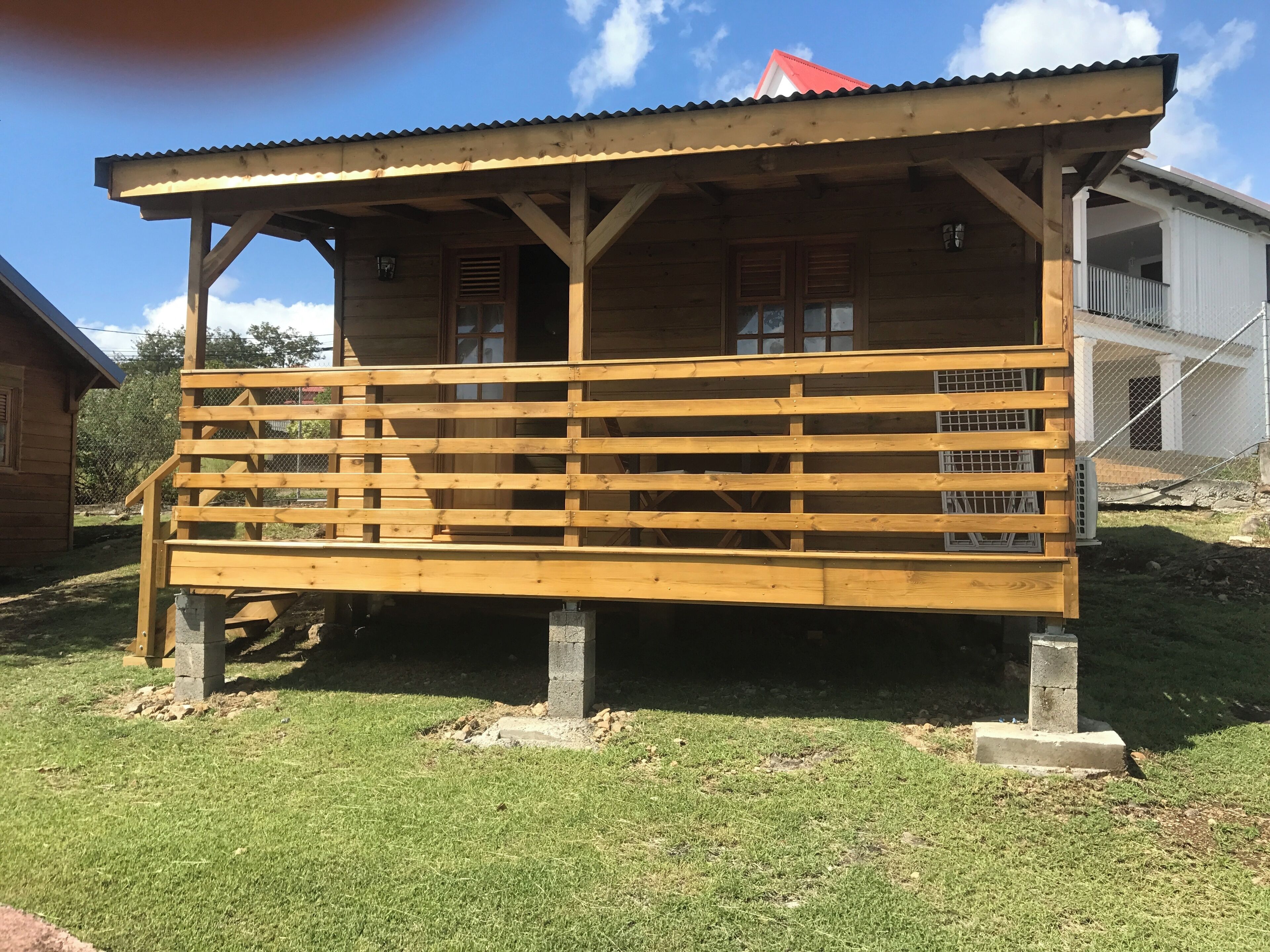 Una estructura de madera con un porche cubierto y una escalera que lleva a él.