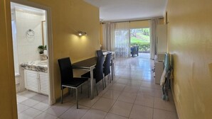 A dining area with a marble countertop and black chairs, leading to a balcony with a view of greenery. - 1 Bed Apt Sleeps 5 - Indoor Pool - Free Parking (San Miguel de Abona)
