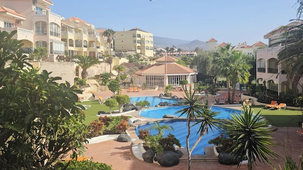 A resort with a central swimming pool, multiple buildings with balconies, and palm trees. - 1 Bed Apt Sleeps 5 - Indoor Pool - Free Parking (San Miguel de Abona)