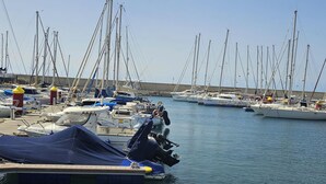 A marina with multiple sailboats docked, a pier with a covered area, and a clear sky. - 1 Bed Apt Sleeps 5 - Indoor Pool - Free Parking (San Miguel de Abona)
