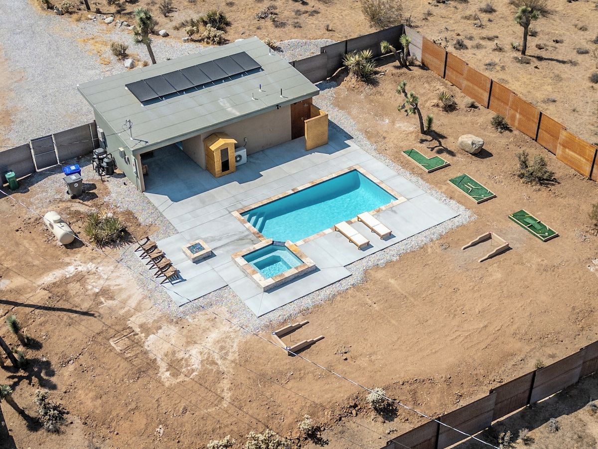 Une maison moderne dotée d’une piscine, d’un espace salon extérieur et d’une cour clôturée.
