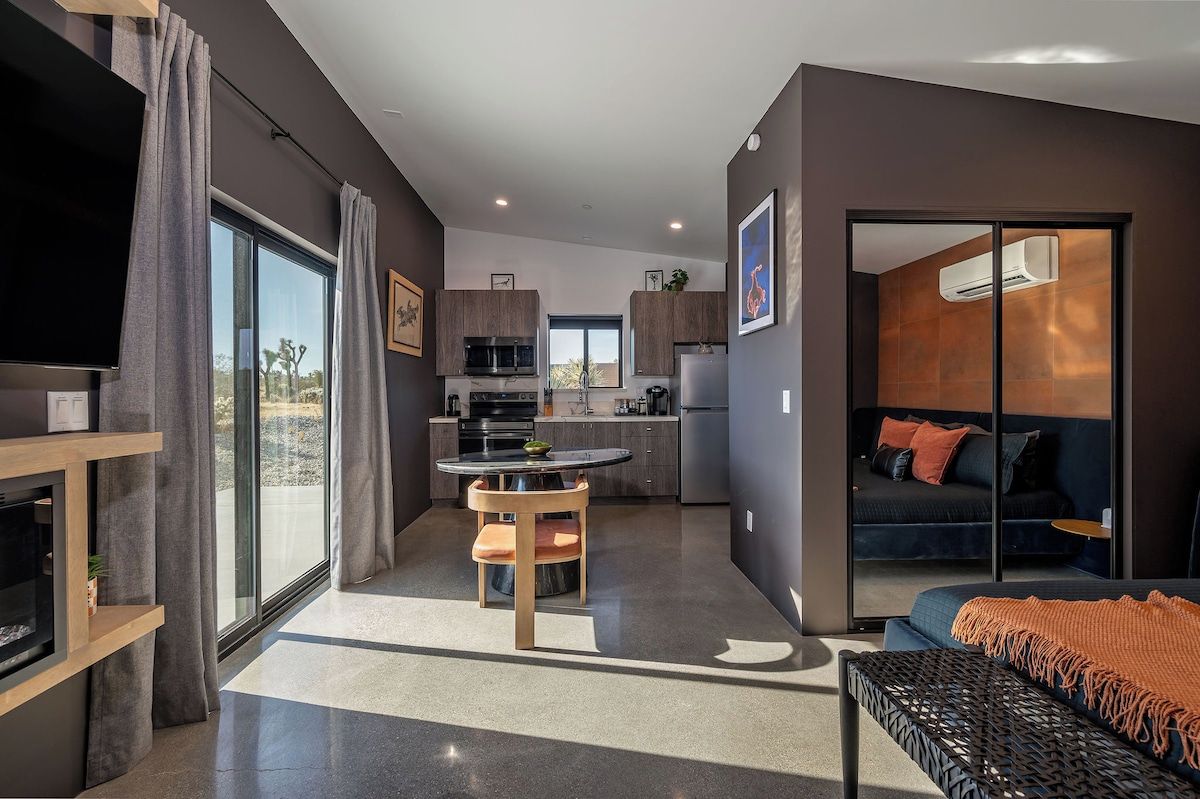 Open-plan tiny home interior with a cozy living area, dining table