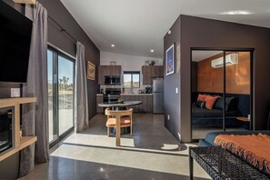 Open-plan tiny home interior with a cozy living area, dining table