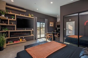 Cozy studio living and sleeping area with a king bed, electric fireplace