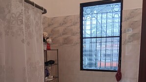 Un baño con inodoro, lavabo, ventana y cortina de ducha.