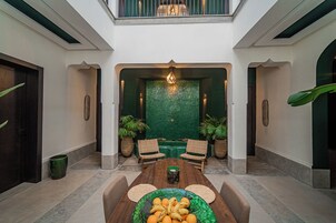 Un'ampia area interna con un tavolo al centro, due sedie e un pannello decorativo.