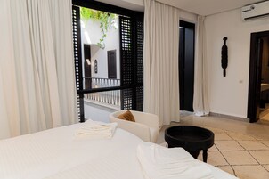 Camera d'albergo con un letto, un tavolino e vista all'esterno.