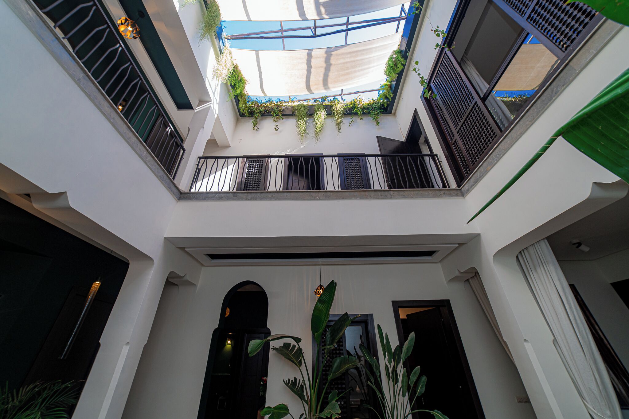 A multi-level atrium with balconies, large windows, and indoor plants.