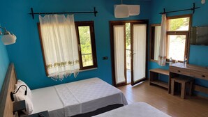Una habitación con dos camas, un escritorio, una silla, un televisor y una ventana con cortinas.