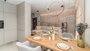 Una zona de menjador moderna amb una taula de fusta preparada per a quatre persones, envoltada de cadires tapissades de color gris.