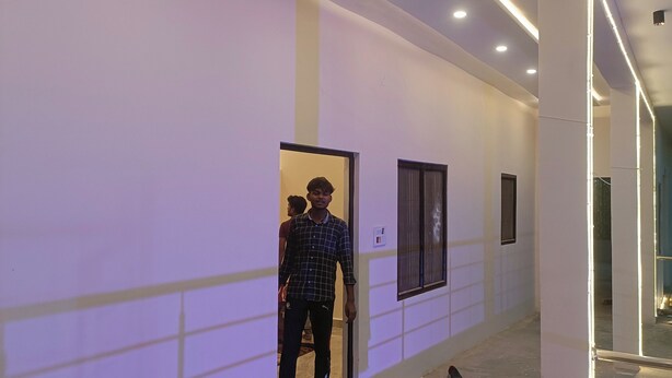 A hallway with a modern design, featuring recessed lighting and a tiled floor. - Madhur Kunj Guest House Pick and Drop (Faizabad)