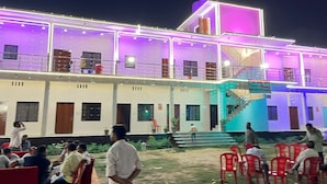 A building with multiple floors, outdoor seating area, and a staircase leading to the upper levels. - Madhur Kunj Guest House Pick and Drop (Faizabad)