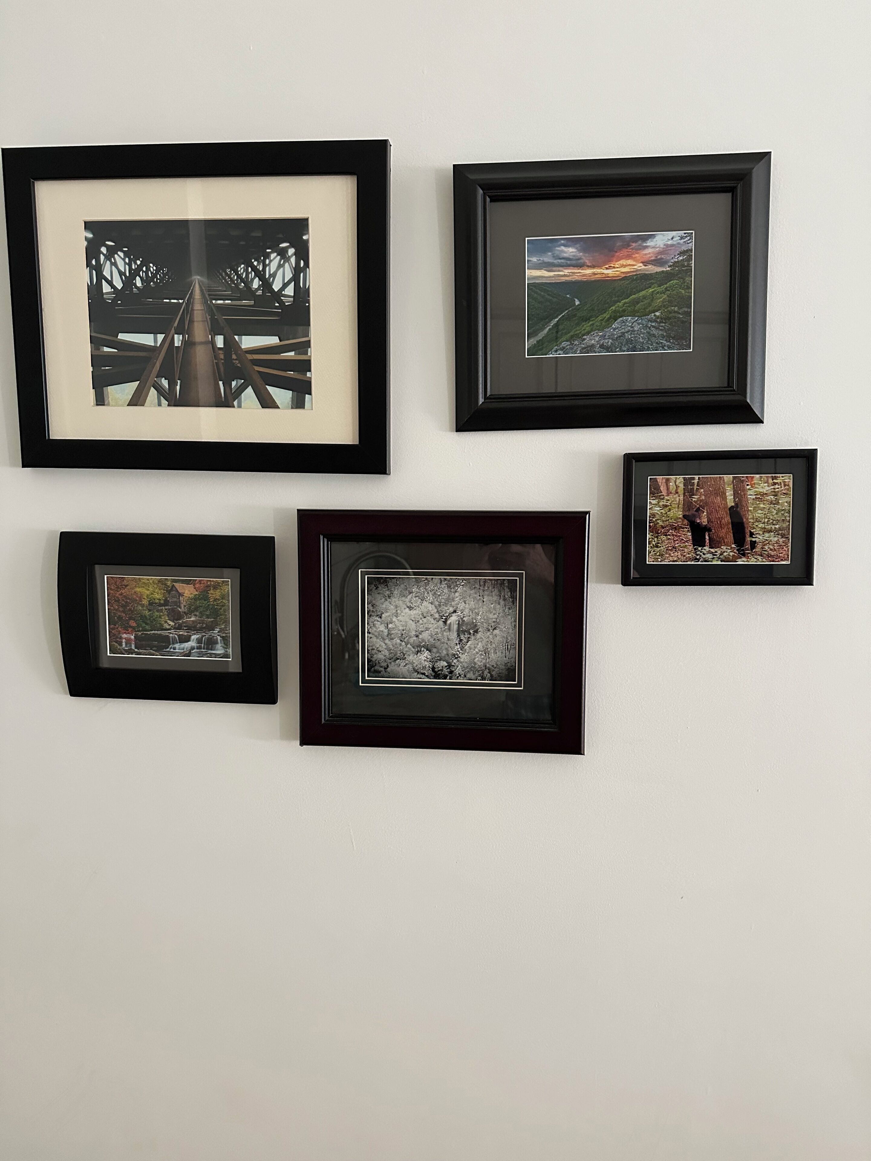 Five framed photographs on a wall.