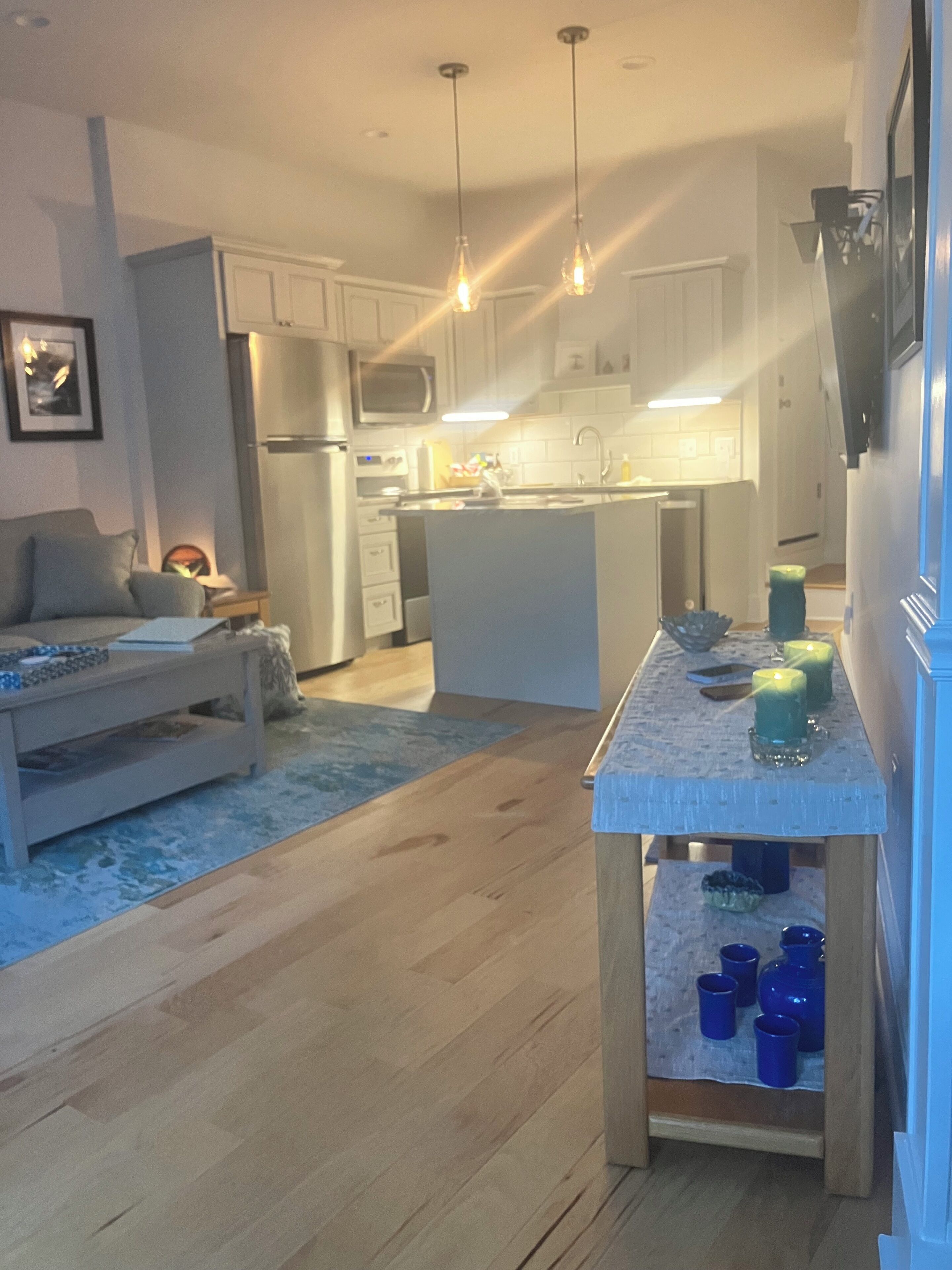 A modern kitchen with white cabinets, a central island, and pendant lighting.