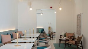 Ein modernes Interieur mit Sitzgelegenheiten, Tischen und hängenden Lampen.