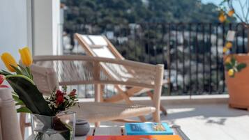Una mesa de madera con un libro titulado "CAPRI DOLCE VITA" y un jarrón con flores.