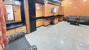 A modern lobby with a reception desk, seating area, and a television. - SwagStay Hotel Rahul Palace Nagpur (Nagpur)