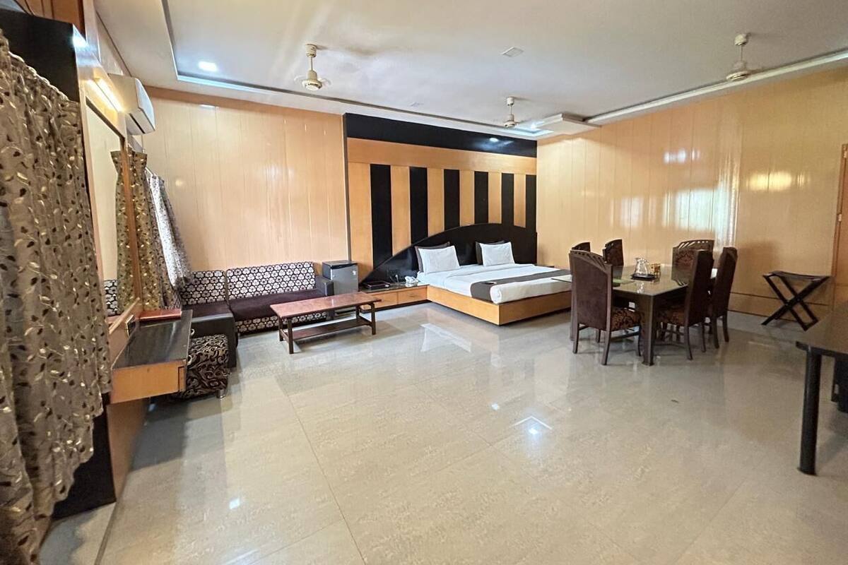 Quarto de hotel moderno com sofá, mesa de jantar e cadeiras.