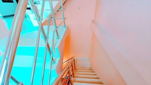 A staircase with metal railings and a checkered floor pattern. - Hotel Raghukul (Faizabad)