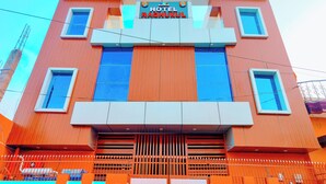 A hotel with a modern facade, large windows, and a prominent sign. - Hotel Raghukul (Faizabad)