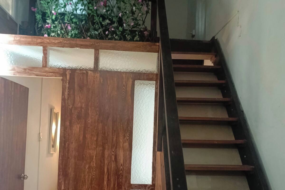 Una escalera de madera con una puerta de cristal que da a una habitación.