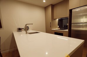 A modern kitchen with a large island, stainless steel appliances, and a minimalist design.