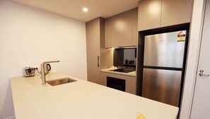 A modern kitchen with a stainless steel refrigerator, a built-in oven, and a sink. - Red Rose Retreat - 1bd 1bth Apt (Phillip)