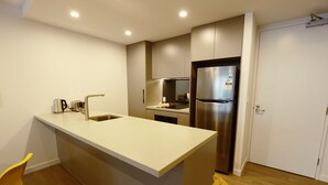 A modern kitchen with a central island, stainless steel appliances, and a built-in oven. - Modern 1Bd Woden | Free Parking | Professionals (Phillip)