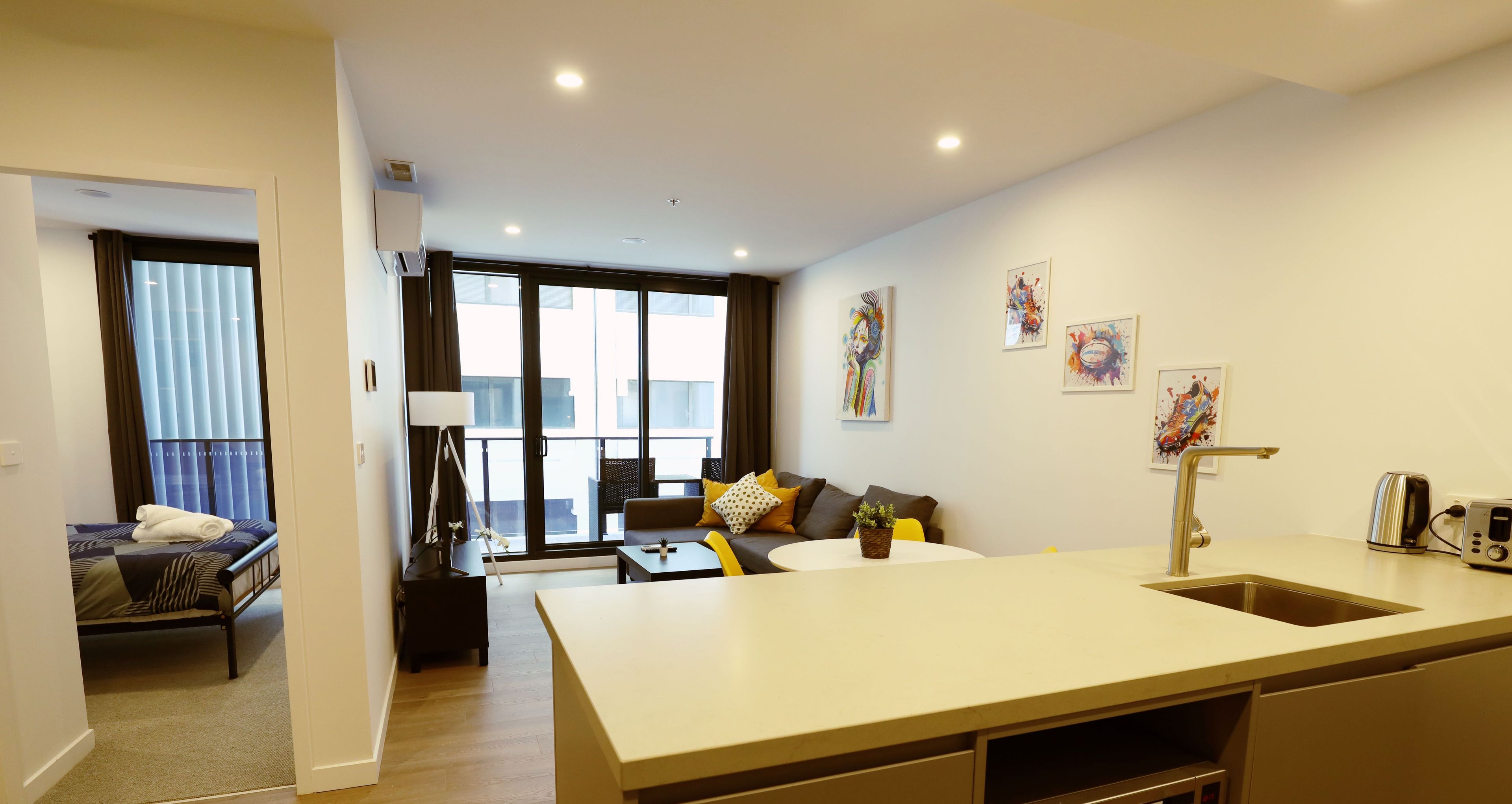 A modern apartment with a kitchen, dining area, and a living room.