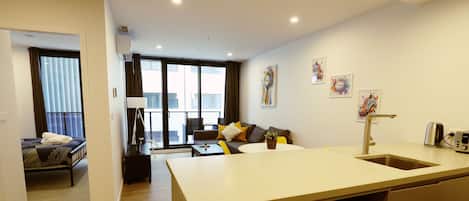 A modern apartment with a kitchen, dining area, and a living room.