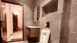 A modern bathroom with a toilet, sink, and mirror. - Hotel Ram Anandam Inn (Faizabad)