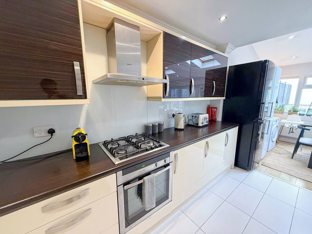 A modern kitchen with a gas stove, oven, and a black refrigerator.