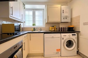 A compact kitchen with a dishwasher, a washing machine, and a window above the sink. - 2-Bed flat with Washer/Dryer in Vauxhall near Oval (London)