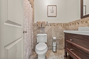 Un baño con inodoro, lavabo y tocador con cajones.