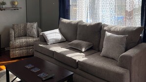 A living room with a sofa, armchairs, a coffee table, a ceiling fan, and a window with curtains. - Charming 3 Bedroom House away from it all but Close to everything (Odessa)
