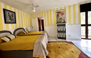 A room with two beds, a ceiling fan, a framed picture on the wall, and a poster. - Detached apartment with sea views in a private estate (Marbella)
