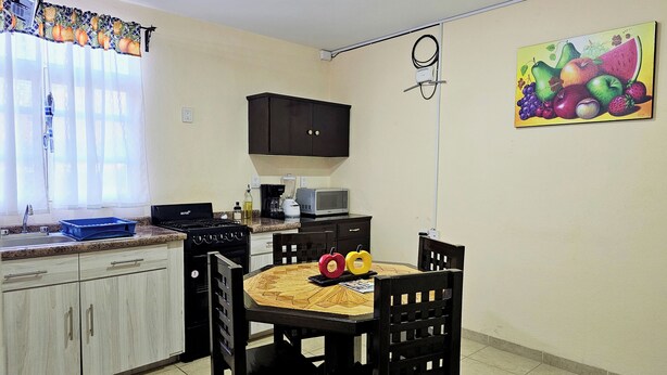 A kitchen with a dining table, chairs, a stove, and a microwave. - Apartment in Tehuacan 2 bedrooms, WiFi, equipped kitchen and close to downtown (Tehuacán)