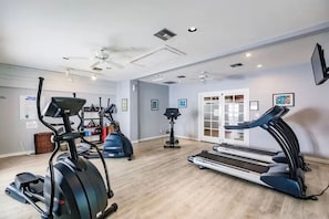 A gym with treadmills, elliptical machines, and a stationary bike.