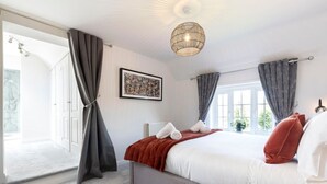 Quarto com cama, radiador, janela e porta que dá para uma varanda.